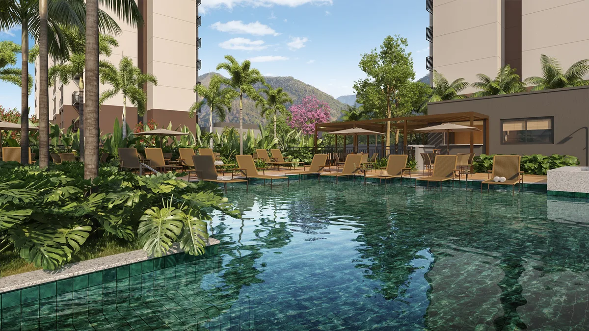 Piscina cercada de jardins tropicais e espreguiçadeiras